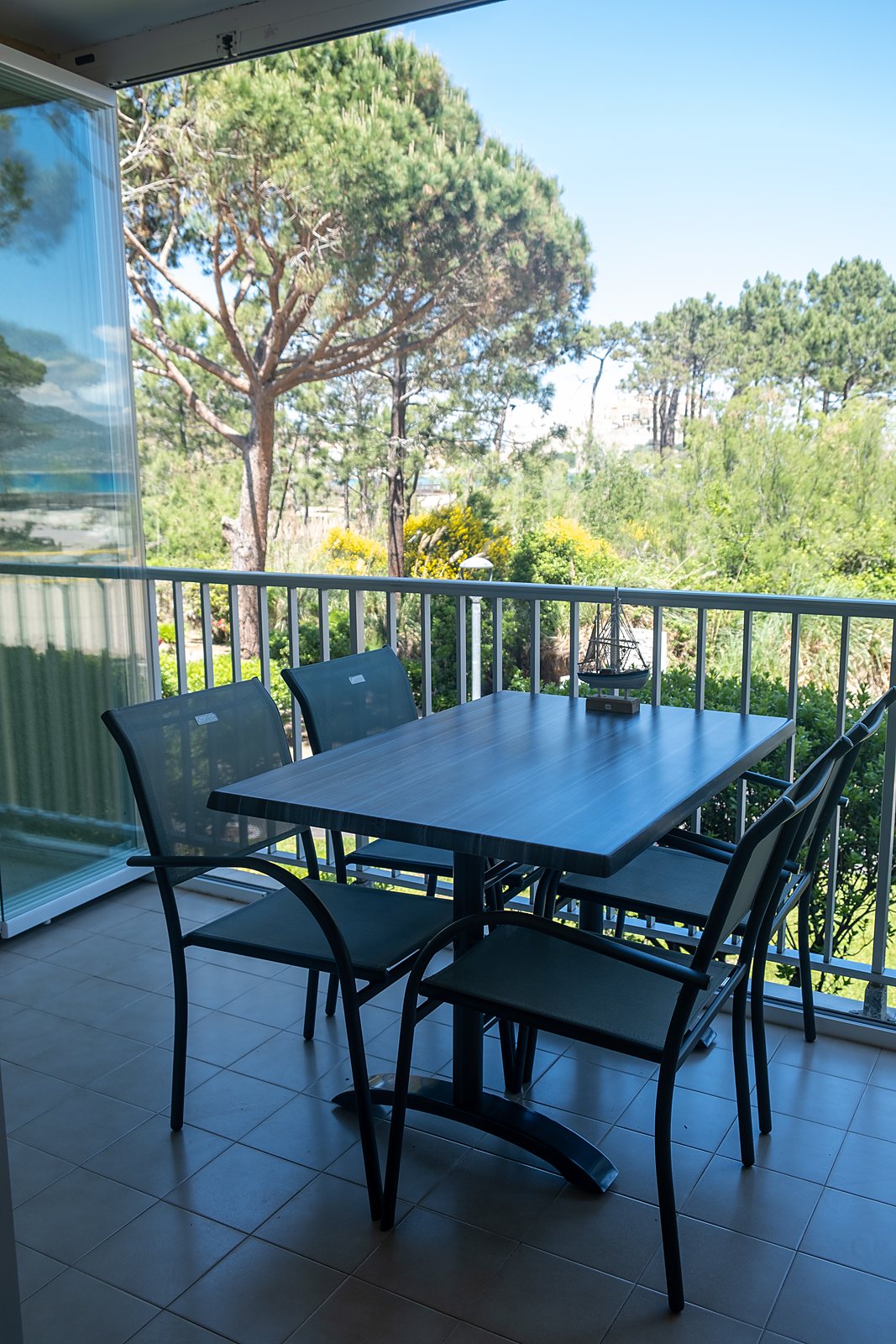 Balkon mit Tisch und Stühlen im Grünen