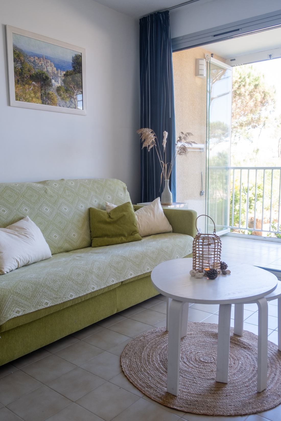 Wohnzimmer mit Schlafsofa und offener Balkontür